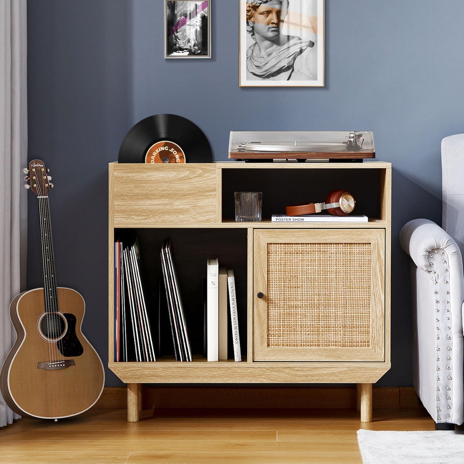 Rattan vinyl record player stand with album storage, solid wood legs, and a turntable on top, placed in a modern living room.